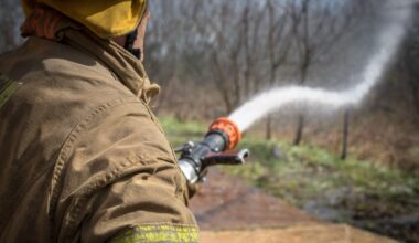 A firefighter sprays a fire with a water hose.
