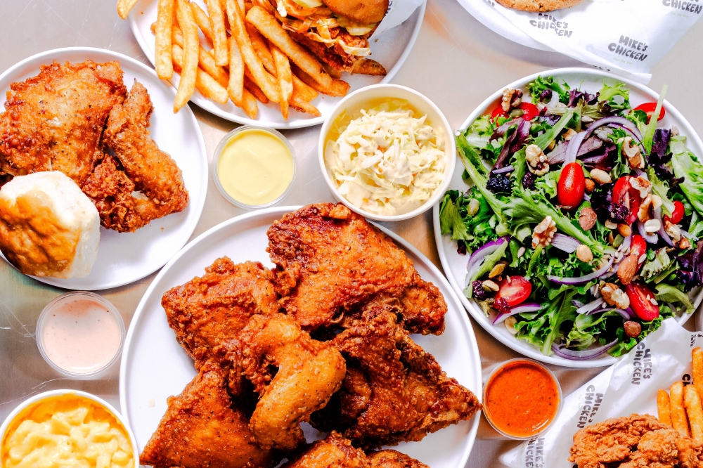 Overview of a variety of dishes filled with fried chicken and sides.