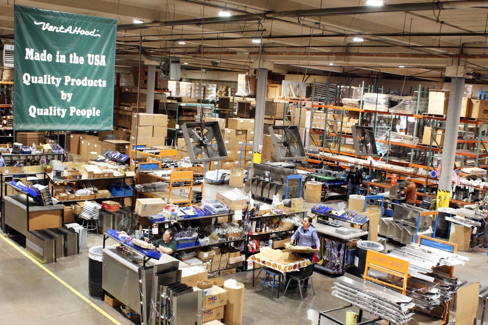 Overview of a factory floor featuring a banner with Vent-A-Hood lettering.