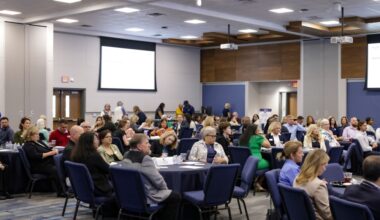 people sitting at tables in a meeting room