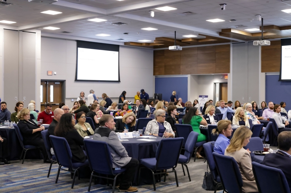 people sitting at tables in a meeting room