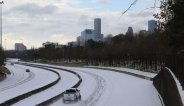 A white truck drives on the largely empty, snow-covered I-45 in Houston in February 2021.