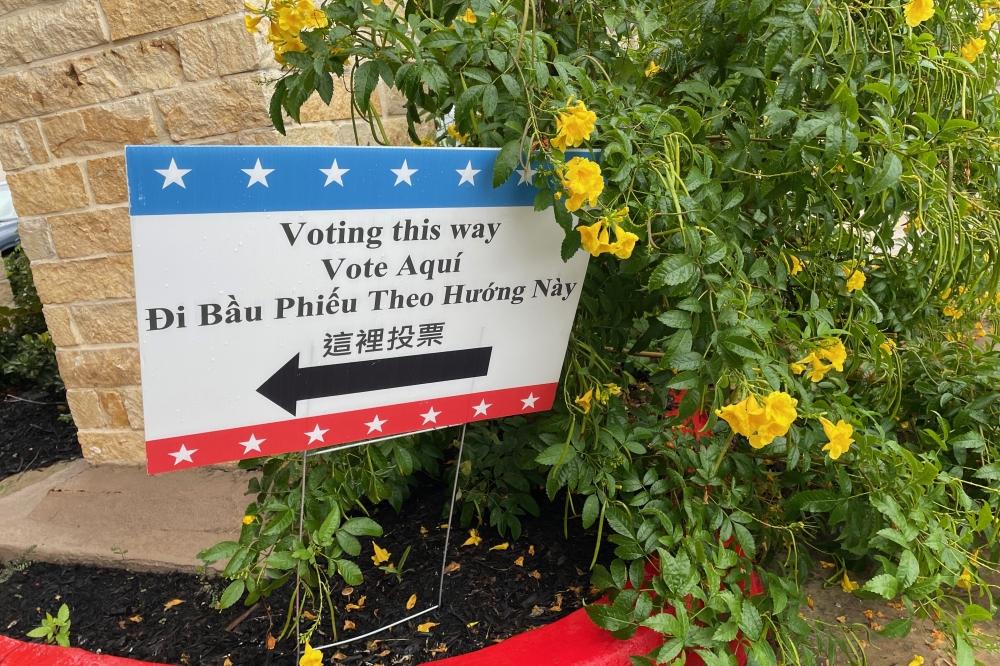 'Voting this way" sign in a flowering bush