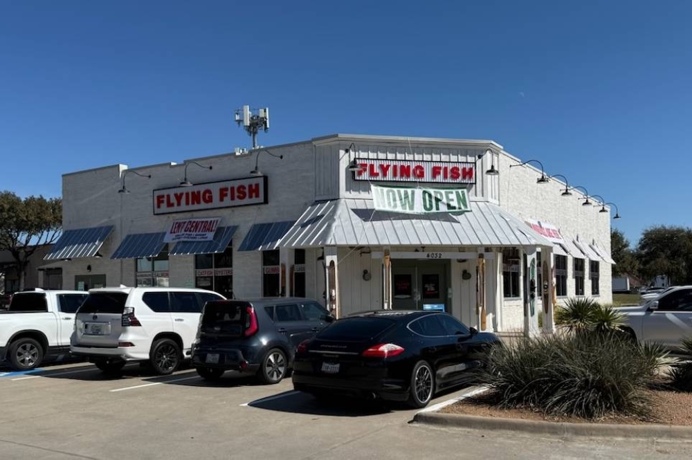 Exterior of a freestanding building featuring Flying Fish signage and now open banners.