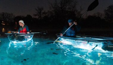 Two peopl ein kayaks are shown. The kayaks light up on the bottom with the blue water.