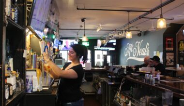 Rachel, a bartender at McNeal’s Tavern in downtown Plano, serves patrons. (Michael Crouchley/Community Impact)