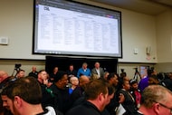 High school football coaches and staff from across North Texas take photos as they react to...