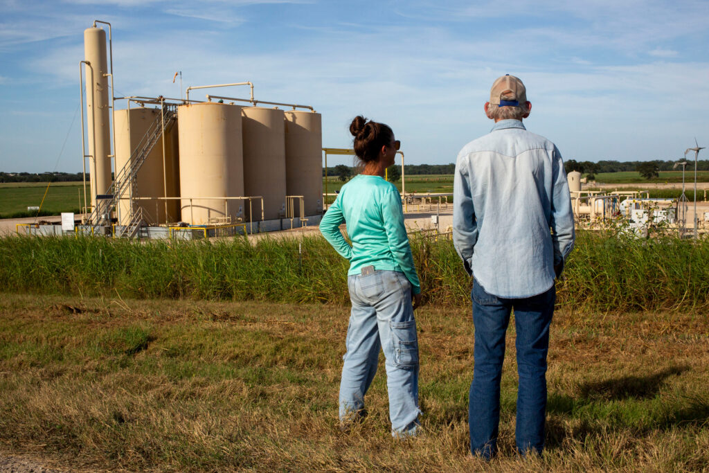 Blake Muir and his niece, Jennifer Sullivan, stand near a tank battery on his land in Gonzales County. Data shows it could come under nearly 15 feet of water in a 500-year flood. Credit: Dylan Baddour/Inside Climate News