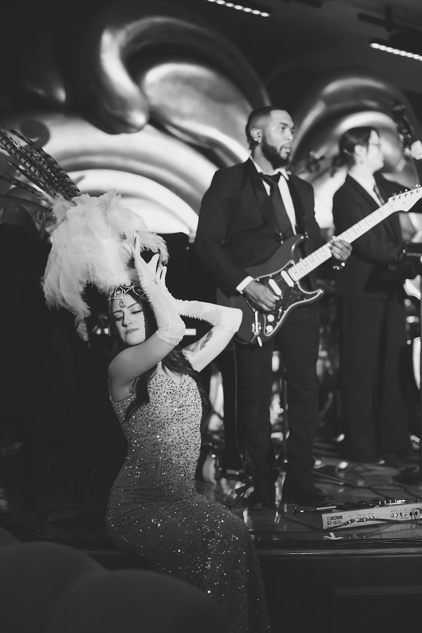 Delilah Dallas' dancers perform on three platforms while a band plays on a larger stage at...