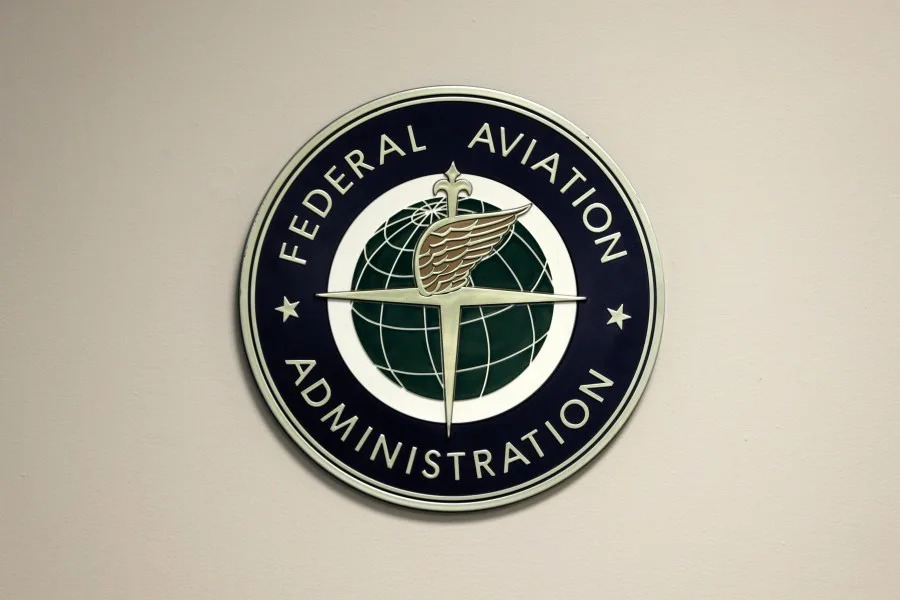 FILE – A Federal Aviation Administration sign hangs in the tower at John F. Kennedy International Airport in New York, March 16, 2017. (AP Photo/Seth Wenig, File)