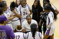 Lincoln's head coach Ashley Greer, center, talks to his players during a timeout in the...