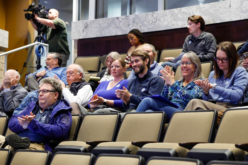 Attendees clap after Plano City Council members approved an interlocal agreement between the...