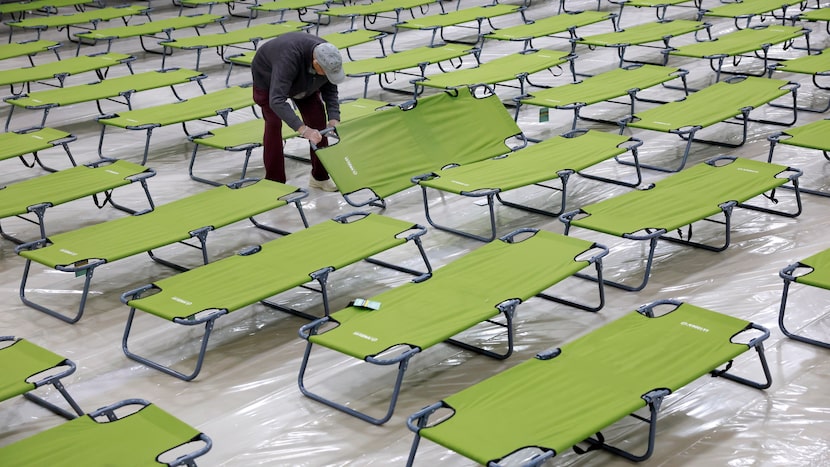 A volunteer sets up cots for those seeking shelter from the cold in the Plano Overnight...