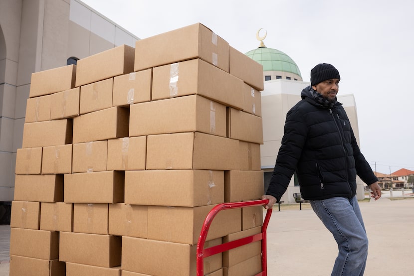 Then-board president Abdullah Shegow wheels out boxes of food during the Help Your Neighbor...
