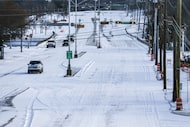 Garland Rd near White Rock Lake covered in snow on Monday morning as a winter storm brings...