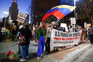Demonstrators carry signs and chant at the corner of Commerce and Harwood Streets during a...