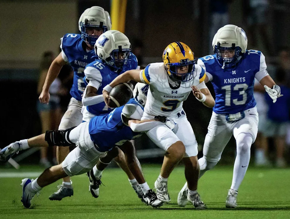 Anderson quarterback Mason Randolph (9) runs the ball through McCallum defense in the second half of the Shoal Creek Showdown as the McCallum Knights and Anderson Trojans open their football season at House Park in Austin, Aug. 28, 2025. The Trojans won the game 37-2. (Sara Diggins/Austin American-Statesman)