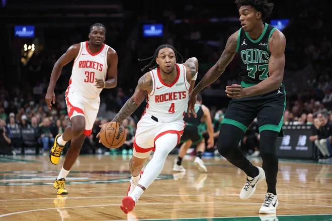 Nov 1, 2025; Boston, Massachusetts, USA; Houston Rockets guard JD Davison (4) drives to the basket defended by Boston Celtics center Amari Williams (77) during the second half at TD Garden. Mandatory Credit: Paul Rutherford-Imagn Images