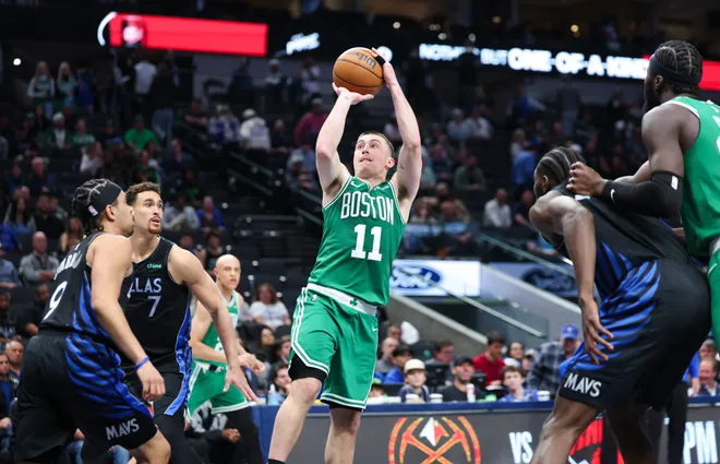 Feb 3, 2026; Dallas, Texas, USA; Boston Celtics guard Payton Pritchard (11) shoots over Dallas Mavericks guard Ryan Nembhard (9) and forward Dwight Powell (7) during the second half at American Airlines Center. Mandatory Credit: Kevin Jairaj-Imagn Images