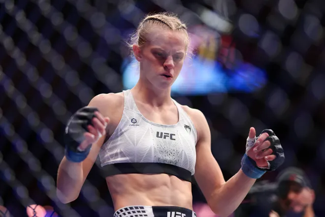 Feb 21, 2026; Houston, Texas, USA; Juliana Miller (red gloves) fights Carli Judice (blue gloves) in a womens flyweight bout during UFC Fight Night at Toyota Center. Mandatory Credit: Troy Taormina-Imagn Images