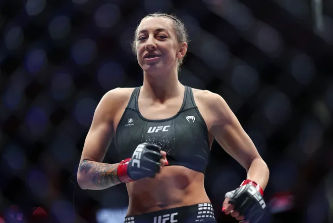 Feb 21, 2026; Houston, Texas, USA; Juliana Miller (red gloves) fights Carli Judice (blue gloves) in a womens flyweight bout during UFC Fight Night at Toyota Center. Mandatory Credit: Troy Taormina-Imagn Images