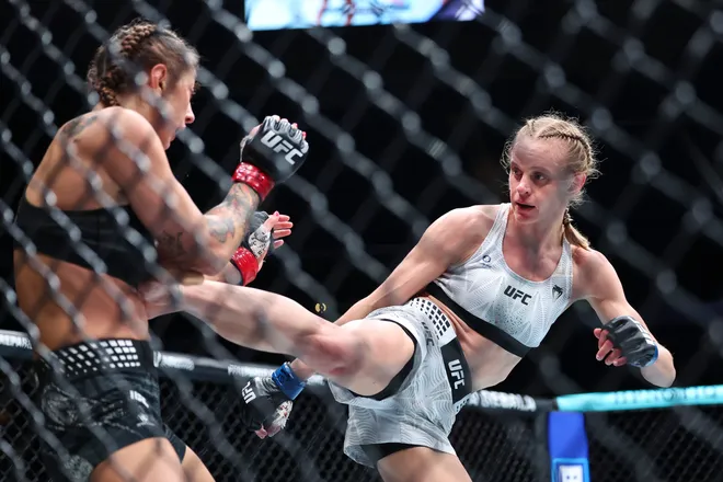 Feb 21, 2026; Houston, Texas, USA; Juliana Miller (red gloves) fights Carli Judice (blue gloves) in a womens flyweight bout during UFC Fight Night at Toyota Center. Mandatory Credit: Troy Taormina-Imagn Images