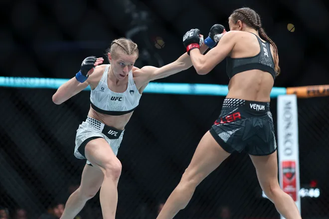 Feb 21, 2026; Houston, Texas, USA; Juliana Miller (red gloves) fights Carli Judice (blue gloves) in a womens flyweight bout during UFC Fight Night at Toyota Center. Mandatory Credit: Troy Taormina-Imagn Images