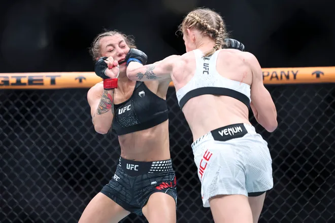 Feb 21, 2026; Houston, Texas, USA; Juliana Miller (red gloves) fights Carli Judice (blue gloves) in a womens flyweight bout during UFC Fight Night at Toyota Center. Mandatory Credit: Troy Taormina-Imagn Images