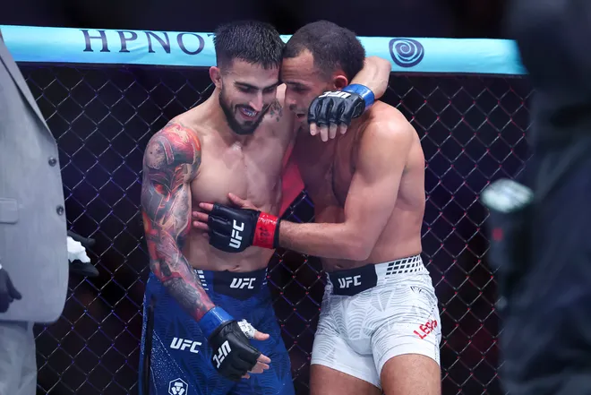 Feb 21, 2026; Houston, Texas, USA; Jordan Leavitt (red gloves) fights Yadier del Valle (blue gloves) in a featherweight bout during UFC Fight Night at Toyota Center. Mandatory Credit: Troy Taormina-Imagn Images