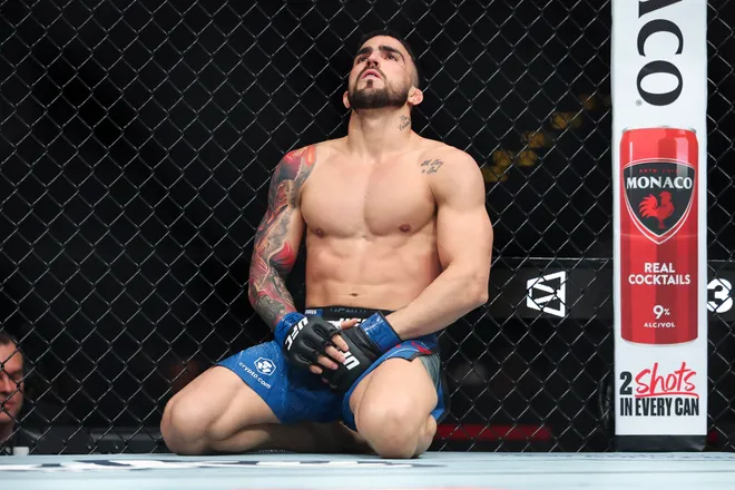 Feb 21, 2026; Houston, Texas, USA; Jordan Leavitt (red gloves) fights Yadier del Valle (blue gloves) in a featherweight bout during UFC Fight Night at Toyota Center. Mandatory Credit: Troy Taormina-Imagn Images