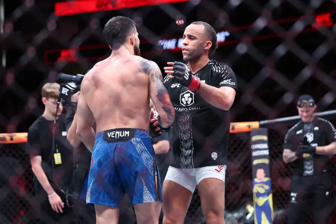 Feb 21, 2026; Houston, Texas, USA; Jordan Leavitt (red gloves) fights Yadier del Valle (blue gloves) in a featherweight bout during UFC Fight Night at Toyota Center. Mandatory Credit: Troy Taormina-Imagn Images