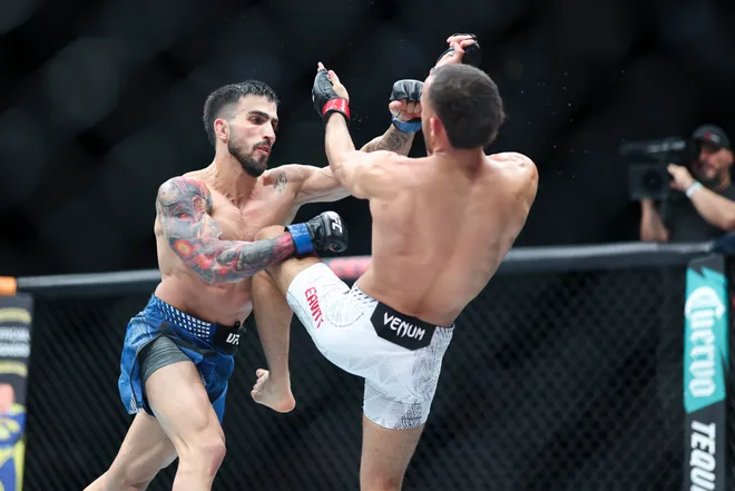 Feb 21, 2026; Houston, Texas, USA; Jordan Leavitt (red gloves) fights Yadier del Valle (blue gloves) in a featherweight bout during UFC Fight Night at Toyota Center. Mandatory Credit: Troy Taormina-Imagn Images