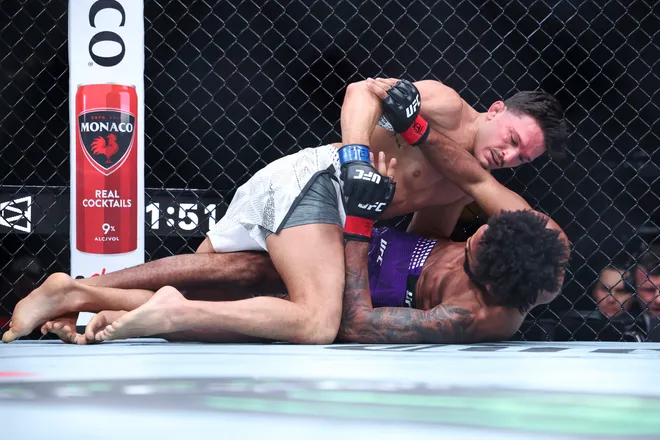 Feb 21, 2026; Houston, Texas, USA; Phil Rowe (red gloves) fights Jean-Paul Lebosnoyani (blue gloves) in a welterweight bout during UFC Fight Night at Toyota Center. Mandatory Credit: Troy Taormina-Imagn Images