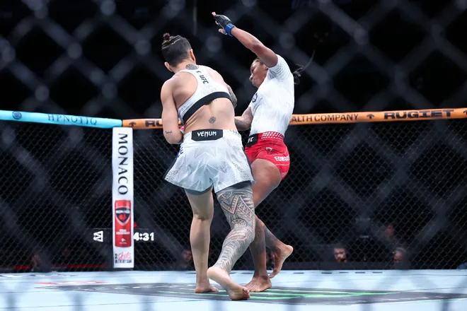 Feb 21, 2026; Houston, Texas, USA; Nora Cornolle (red gloves) fights Joselyne Edwards (blue gloves) in a womens bantamweight bout during UFC Fight Night at Toyota Center. Mandatory Credit: Troy Taormina-Imagn Images