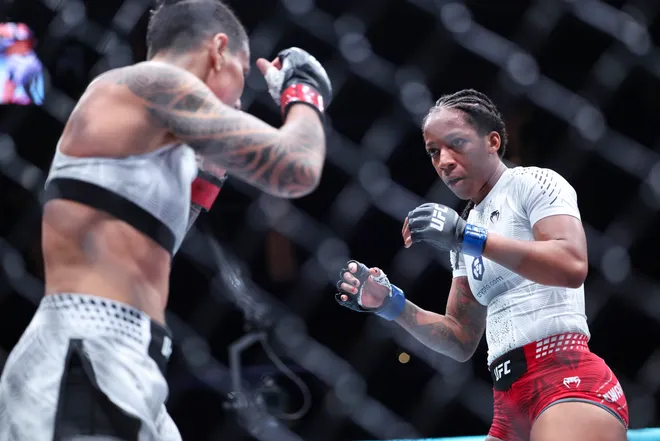 Feb 21, 2026; Houston, Texas, USA; Nora Cornolle (red gloves) fights Joselyne Edwards (blue gloves) in a womens bantamweight bout during UFC Fight Night at Toyota Center. Mandatory Credit: Troy Taormina-Imagn Images