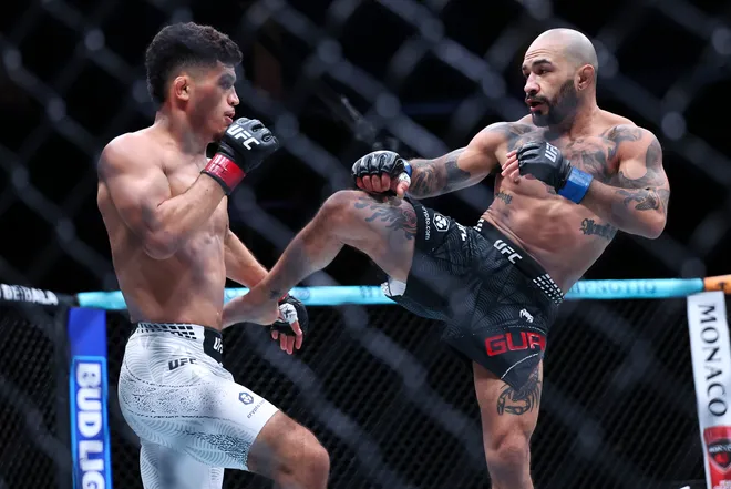 Feb 21, 2026; Houston, Texas, USA; Alden Coria (red gloves) fights Luis Gurule (blue gloves) in a flyweight bout during UFC Fight Night at Toyota Center. Mandatory Credit: Troy Taormina-Imagn Images