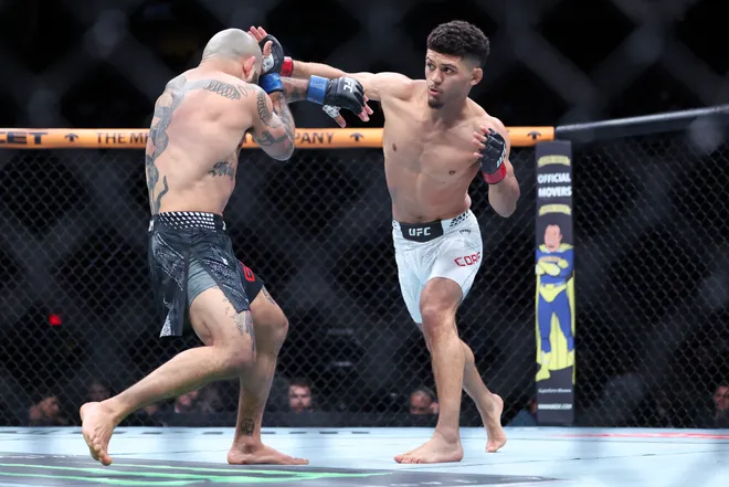 Feb 21, 2026; Houston, Texas, USA; Alden Coria (red gloves) fights Luis Gurule (blue gloves) in a flyweight bout during UFC Fight Night at Toyota Center. Mandatory Credit: Troy Taormina-Imagn Images