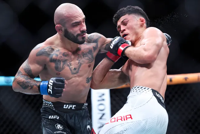 Feb 21, 2026; Houston, Texas, USA; Alden Coria (red gloves) fights Luis Gurule (blue gloves) in a flyweight bout during UFC Fight Night at Toyota Center. Mandatory Credit: Troy Taormina-Imagn Images