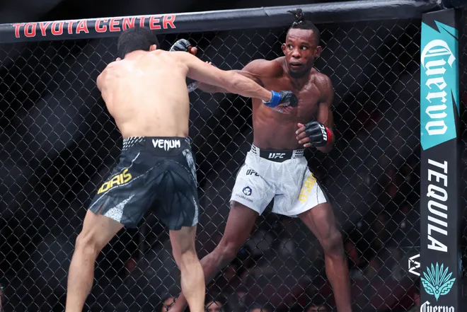 Feb 21, 2026; Houston, Texas, USA; Ode Osbourne (red gloves) fights Alibi Idiris (blue gloves) in a flyweight bout during UFC Fight Night at Toyota Center. Mandatory Credit: Troy Taormina-Imagn Images