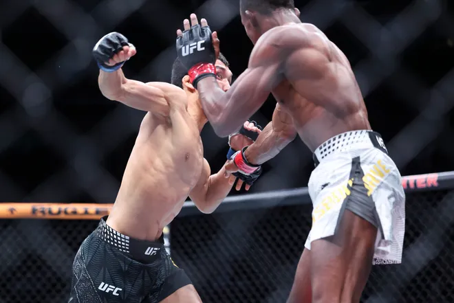 Feb 21, 2026; Houston, Texas, USA; Ode Osbourne (red gloves) fights Alibi Idiris (blue gloves) in a flyweight bout during UFC Fight Night at Toyota Center. Mandatory Credit: Troy Taormina-Imagn Images