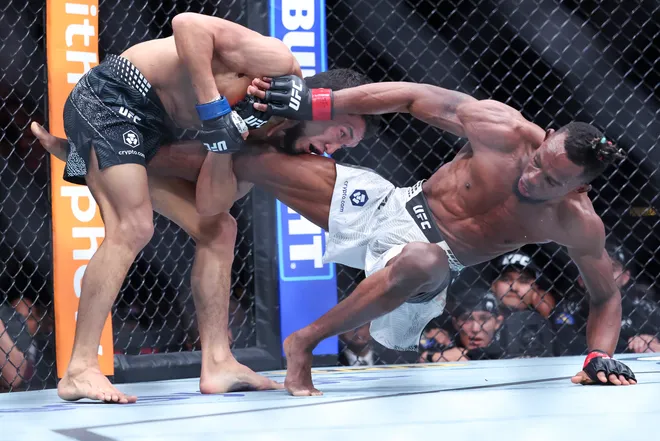 Feb 21, 2026; Houston, Texas, USA; Ode Osbourne (red gloves) fights Alibi Idiris (blue gloves) in a flyweight bout during UFC Fight Night at Toyota Center. Mandatory Credit: Troy Taormina-Imagn Images