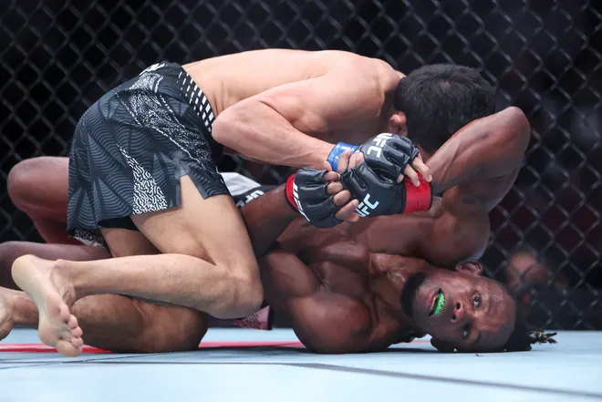 Feb 21, 2026; Houston, Texas, USA; Ode Osbourne (red gloves) fights Alibi Idiris (blue gloves) in a flyweight bout during UFC Fight Night at Toyota Center. Mandatory Credit: Troy Taormina-Imagn Images