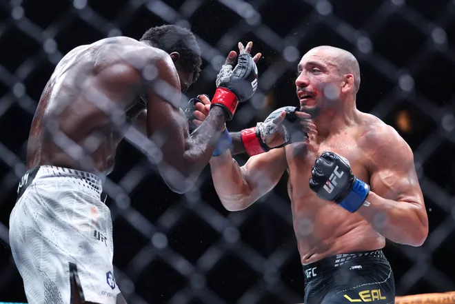 Feb 21, 2026; Houston, Texas, USA; Chidi Njokuani (red gloves) fights Carlos Leal (blue gloves) in a welterweight bout during UFC Fight Night at Toyota Center. Mandatory Credit: Troy Taormina-Imagn Images