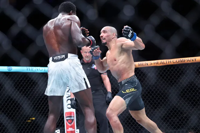 Feb 21, 2026; Houston, Texas, USA; Chidi Njokuani (red gloves) fights Carlos Leal (blue gloves) in a welterweight bout during UFC Fight Night at Toyota Center. Mandatory Credit: Troy Taormina-Imagn Images