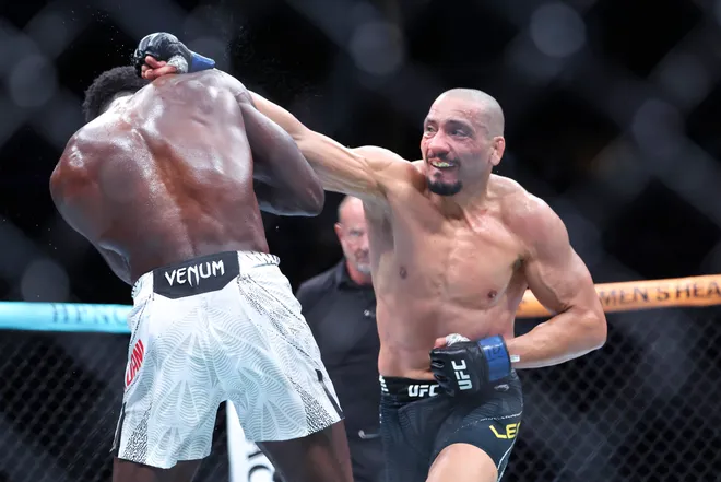 Feb 21, 2026; Houston, Texas, USA; Chidi Njokuani (red gloves) fights Carlos Leal (blue gloves) in a welterweight bout during UFC Fight Night at Toyota Center. Mandatory Credit: Troy Taormina-Imagn Images