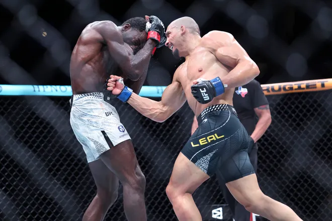 Feb 21, 2026; Houston, Texas, USA; Chidi Njokuani (red gloves) fights Carlos Leal (blue gloves) in a welterweight bout during UFC Fight Night at Toyota Center. Mandatory Credit: Troy Taormina-Imagn Images
