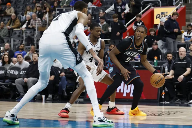 Feb 23, 2026; Detroit, Michigan, USA; Detroit Pistons guard Ausar Thompson (9) dribbles defended by San Antonio Spurs guard De'aaron Fox (4) and forward Victor Wembanyama (1) in the second half at Little Caesars Arena.