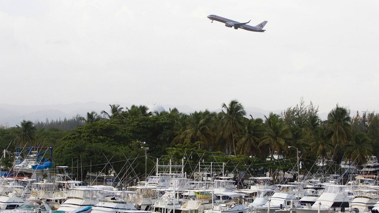 An American Airlines jet lifts off near a marina in San Juan, Puerto Rico, Friday, June 13, 2008. (AP Photo/Brennan Linsley)