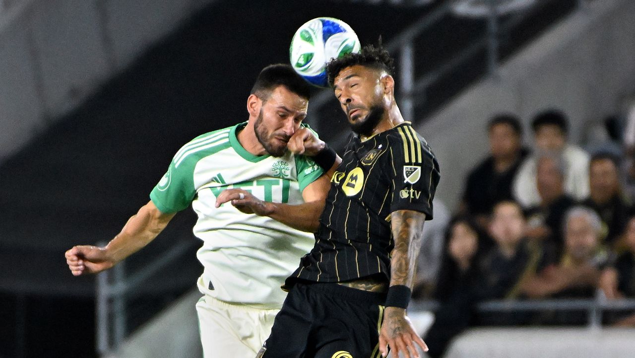 Austin FC defender Brendan Hines-Ike, left, vies for a header with LAFC forward Denis Bouanga during the first half of Game 1 in the first round of MLS soccer's Western Conference playoff Wednesday, Oct. 29, 2025, in Los Angeles. (AP Photo/Wally Skalij)