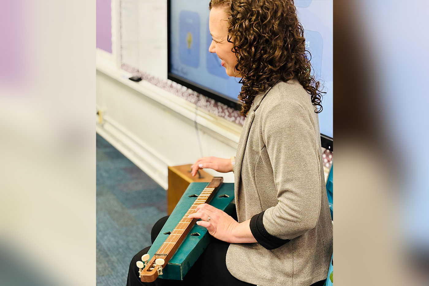 Algate in the classroom with an instrument in her lap